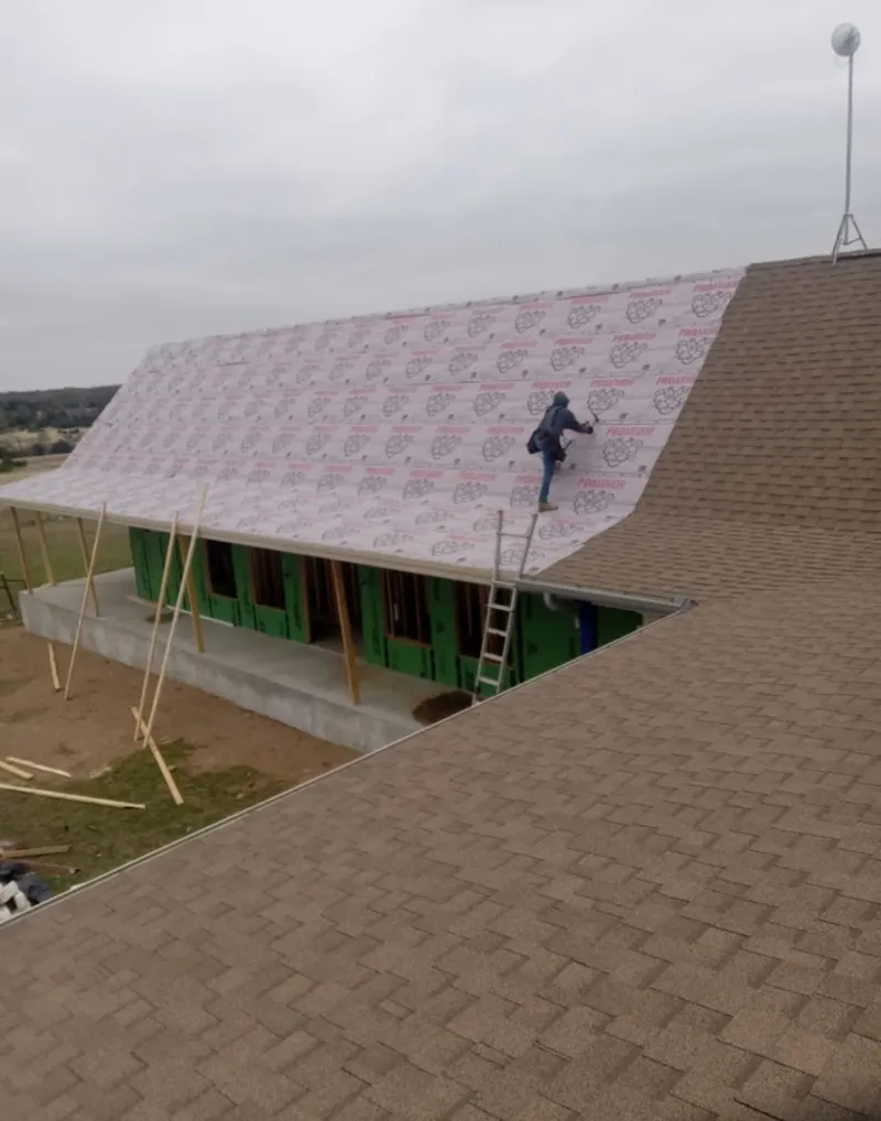 Worker preparing underlayment for a metal roof installation in Hoquiam
